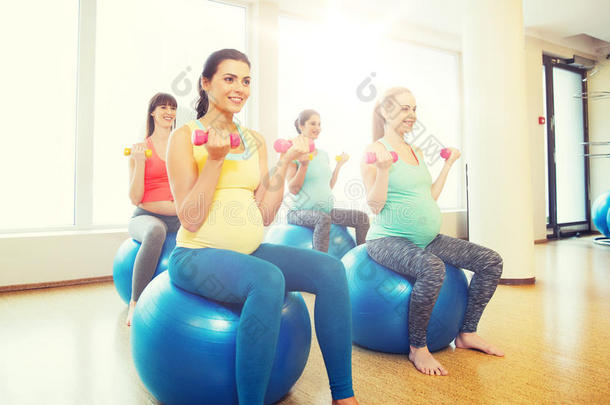 幸福的怀孕的女人锻炼向健身球采用健身房