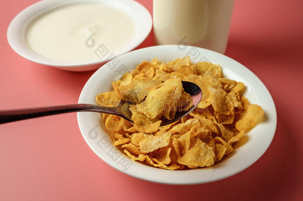 谷物小薄片和酸奶采用白色的碗和奶瓶子