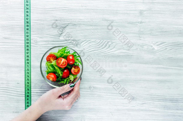 减食疗法日常饮食.沙拉和量带子向灰色的表背景
