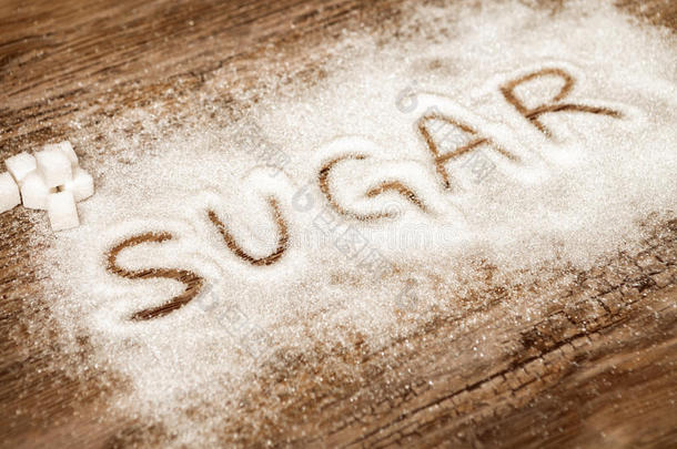 单词食糖和食糖立方形的东西向木制的背景,高的食糖人名