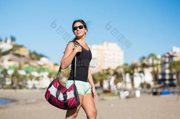 美丽的女人步行向海滩佃户租种的土地袋