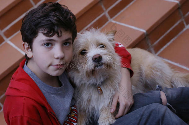 十几岁的青少年男孩热烈地拥抱小猎狗狗