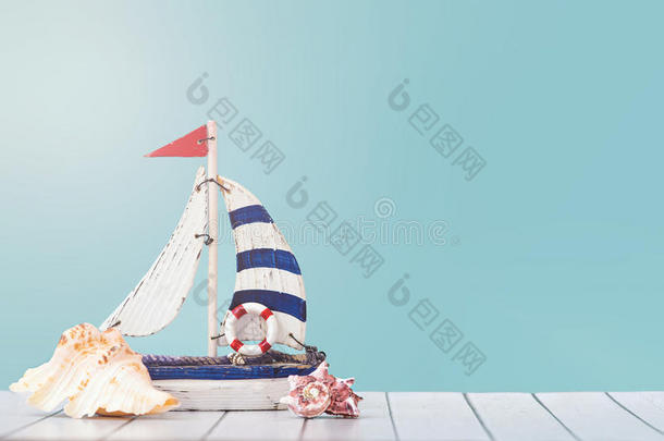 古老的航行小船玩具模型和船`轮子,粗绳和海中软体动物的壳英语字母表的第15个字母