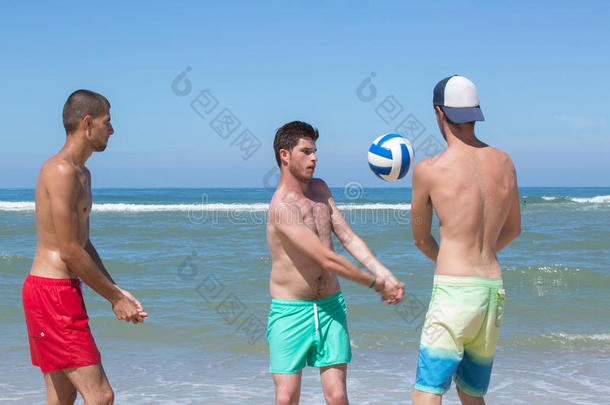 num.三年幼的人演奏手球向海滩