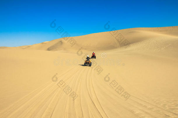 四倍操纵人-两个幸福的骑摩托车的人采用沙沙漠.