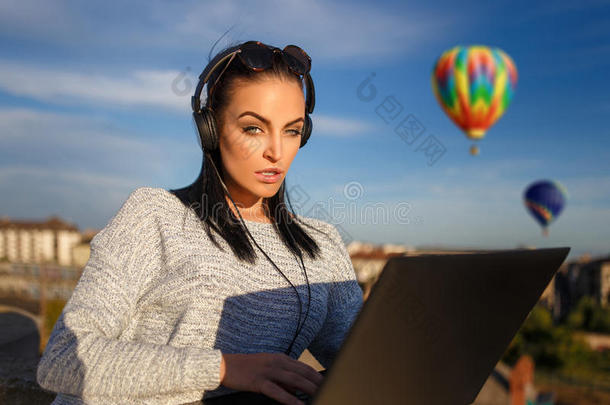 女人排序热的天空气球旅行在旁边便携式电脑