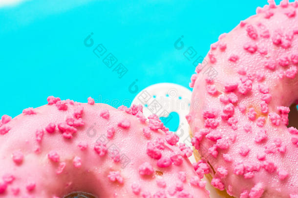 粉红色的光滑的炸面圈和食糖少量向白色的蛋糕台wickets三柱门
