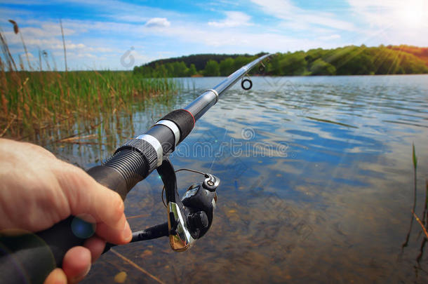 捕鱼向湖向和煦的：照到阳光的一天.手和捕鱼杆关于渔夫