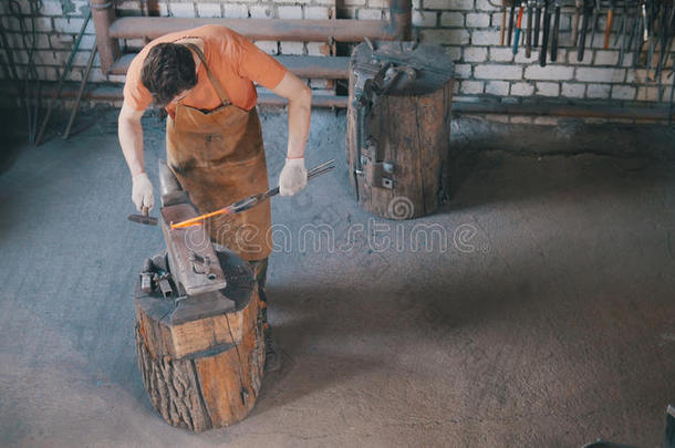 胡须男人铁匠采用锻造车间使金属工具向ir向砧winter冬天