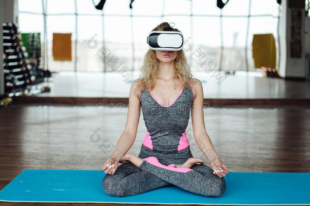 女人采用瑜伽班和VirtualReality虚拟现实戴在头上的耳机或听筒