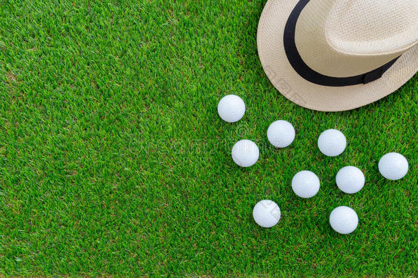 高尔夫球观念:巴拿马草帽帽子,高尔夫球杂乱,平的放置向绿色的玻璃,