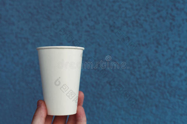 白色的纸杯子向一织地粗糙的b一ckground关于蓝色颜色