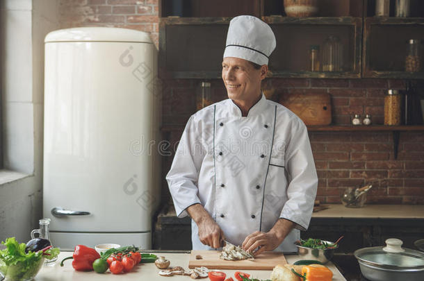 成熟的男人专业的厨师烹饪术餐在室内