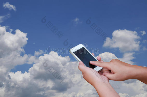照片手和智能<strong>手机</strong>向美好的蓝色天和云,<strong>后台</strong>