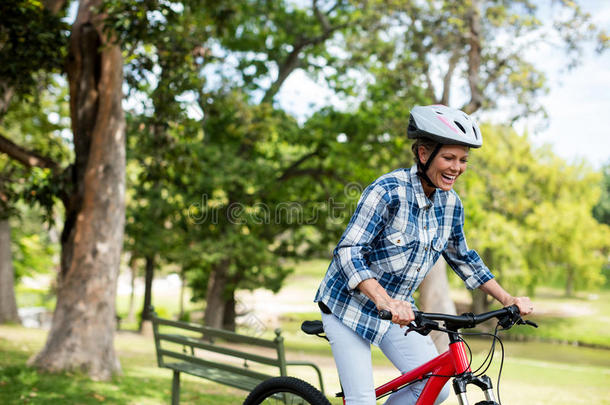 幸福的女人骑脚踏车兜风采用公园