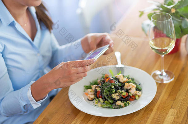 女人和智能<strong>手机摄影</strong>食物在咖啡馆