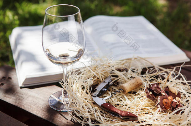 玻璃和白色的葡萄酒看台在近处书,螺杆和巧克力
