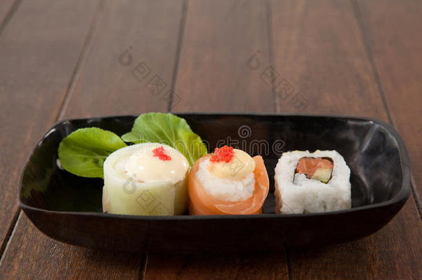 生鱼片寿司和乌拉马基寿司serve的过去式向黑的小船盘子