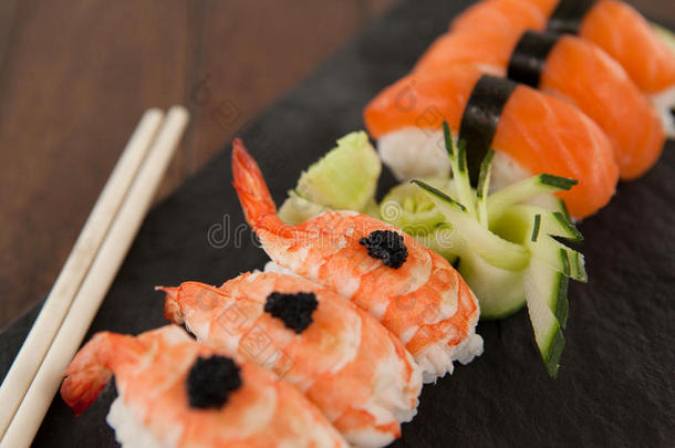 生鱼片寿司寿司serve的过去式和筷子采用黑的石头板岩向木材