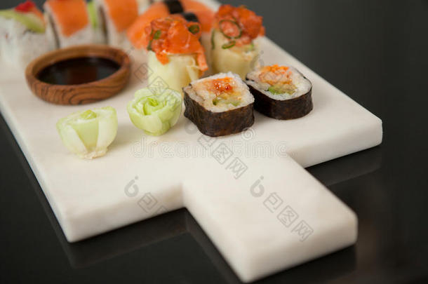 各式各样的寿司放置serve的过<strong>去</strong>式和大豆调<strong>味</strong>汁向白色的板