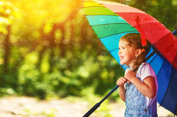幸福的小孩女孩笑声和演奏在下面夏雨和一本姆