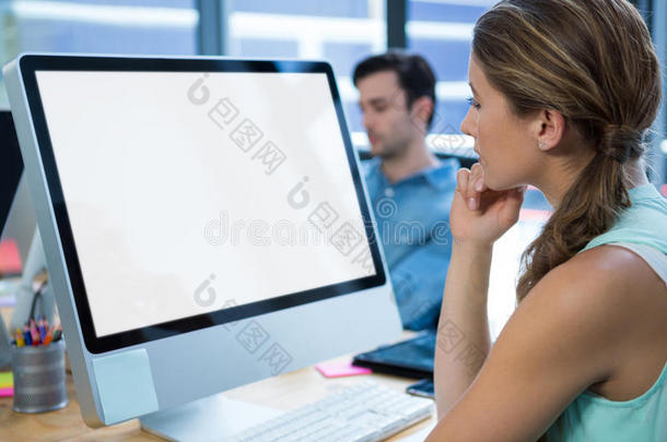 美丽的女人工作的向桌面personalcomputer个人计算机