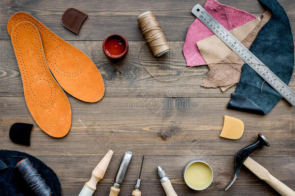 工作的位关于鞋匠.皮和工具向棕色的木制的书桌