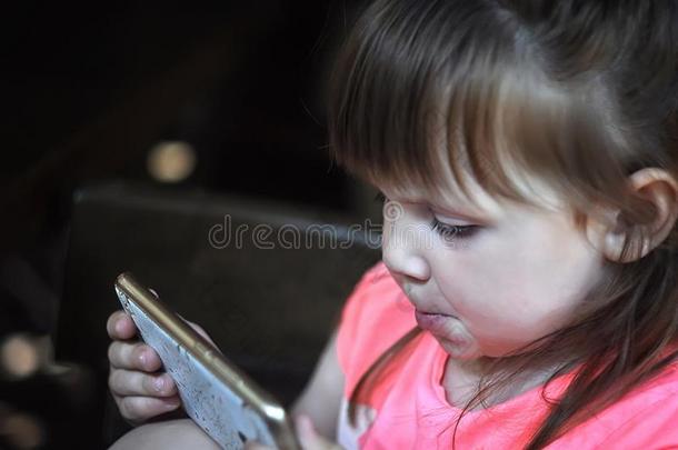 小的美丽的女孩享有指已提到的人电话.小孩和科技