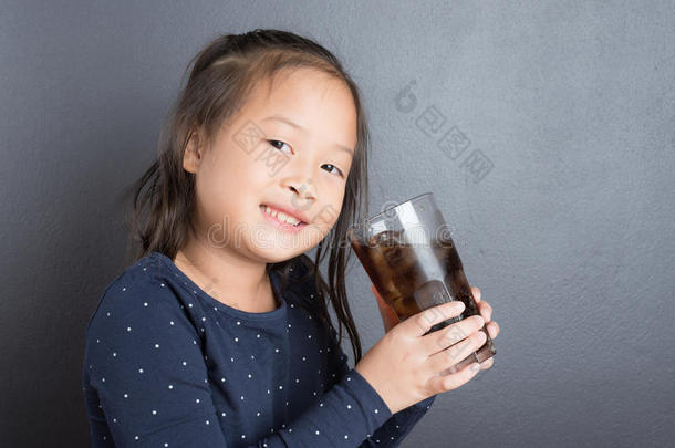 肖像关于亚洲人小的女孩喝可乐果树苏打