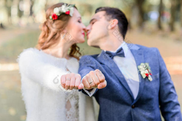 接吻的新婚夫妇到达出局他们的拳和婚礼戒指