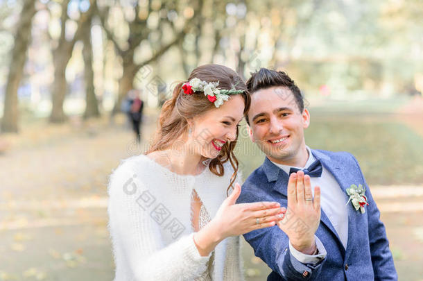 笑的新婚夫妇给看婚礼戒指向他们的手