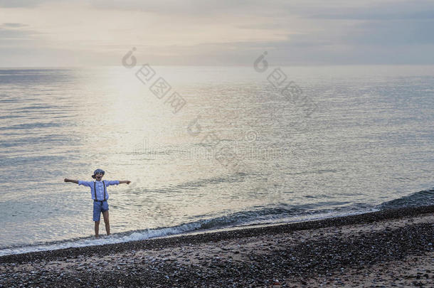 一欢乐的男孩投掷运动岩石在海