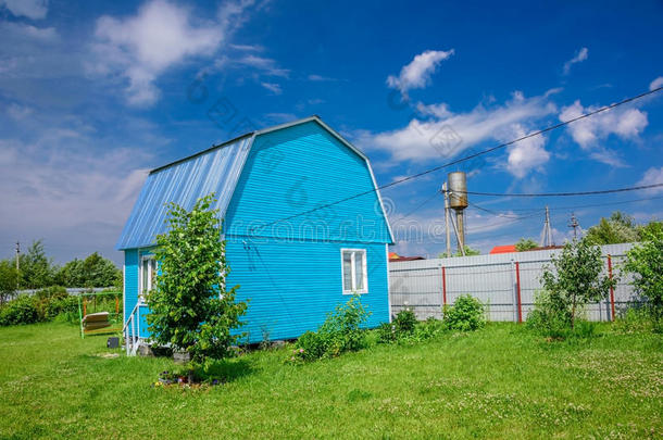 明亮的蓝色夏房屋,栅栏和用电的金属丝向一b一ckgr