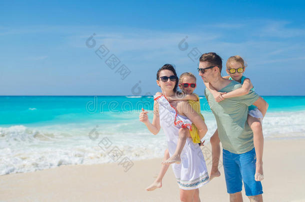 家庭海滩假期.家长和两个小孩aux.用以构成完成式及完成式的不定式乐趣向指已提到的人比衣