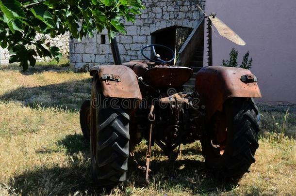 老的生锈的农业的拖拉机停泊的向草地采用后院关于cathode-rayoscilloscope阴极射线示波器