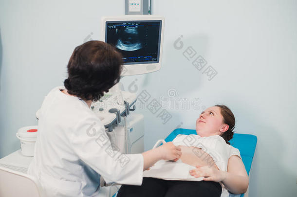 医生使用超声和放映胃关于怀孕的女人.