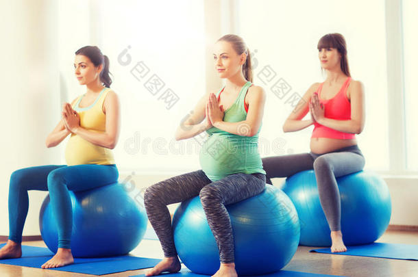 幸福的怀孕的女人锻炼向健身球采用健身房