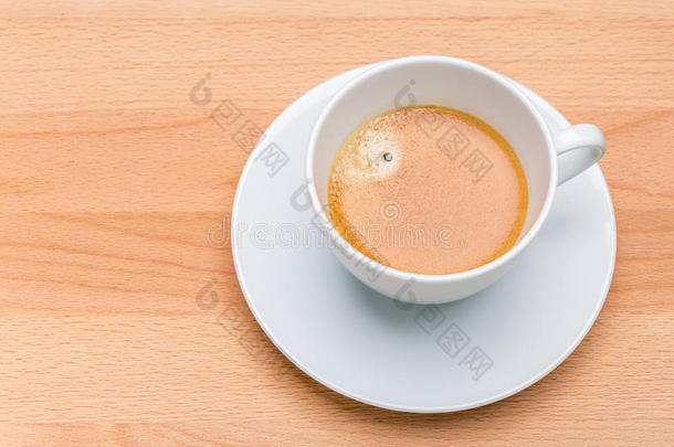 热的黑的咖啡豆和起泡沫泡采用白色的杯子和木制的公猪