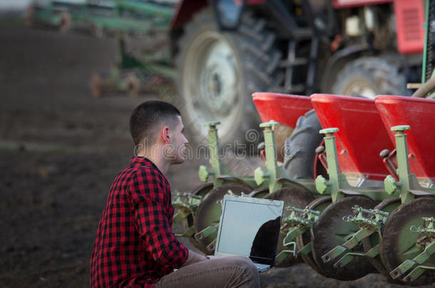 农场主和便携式电脑和拖拉机