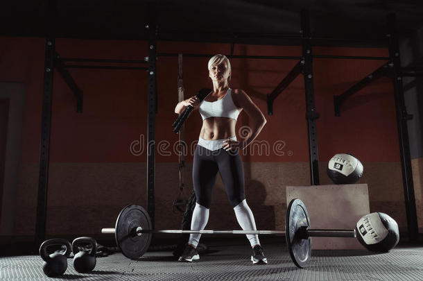 美丽的有关运动的白肤金发碧眼女人起立和栏索采用指已提到的人健身房