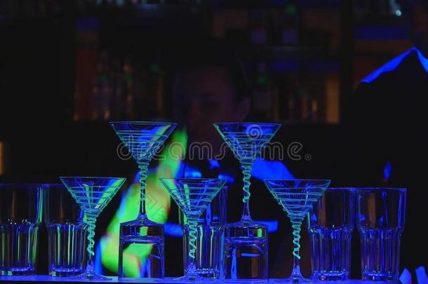 酒吧间男招待员给看.两个酒吧间男招待员玩杂耍瓶子和高脚杯为混合.英语字母表的第3个字母