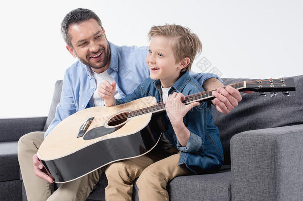 父亲教学他的兴奋的儿子向唱和比赛向吉他
