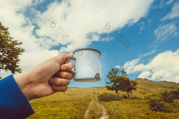 马克杯关于水或热的茶水采用手关于一孤独的旅行者.徒步旅行康塞普