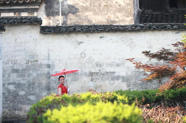 幸福的中国人女人采用红色的<strong>旗袍</strong>旅行在古代的城镇
