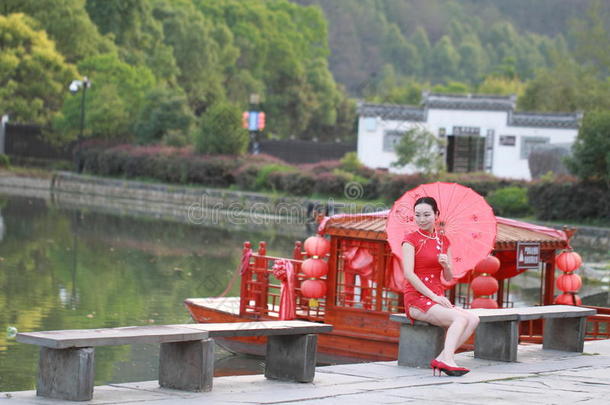 幸福的中国人女人采用红色的<strong>旗袍</strong>旅行在<strong>古代</strong>的城镇