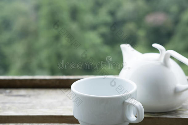 白色的<strong>茶水杯</strong>子和马克杯向木材表和绿色的自然背景