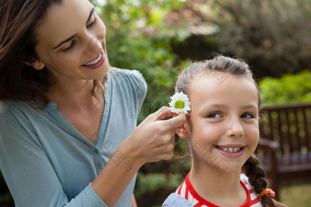 微笑的母亲配置白色的花采用头发关于女孩