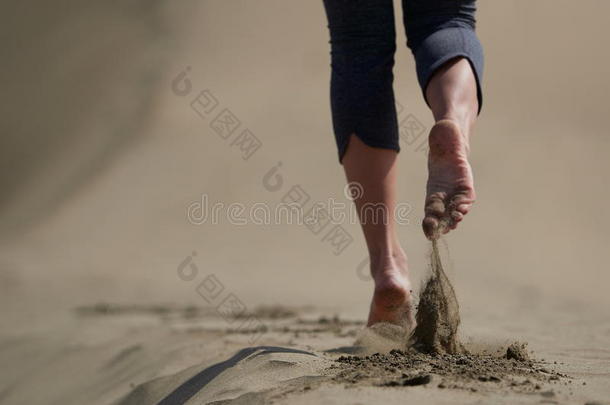 光秃秃的脚关于年幼的女人慢跑/步行向指已提到的人海滩