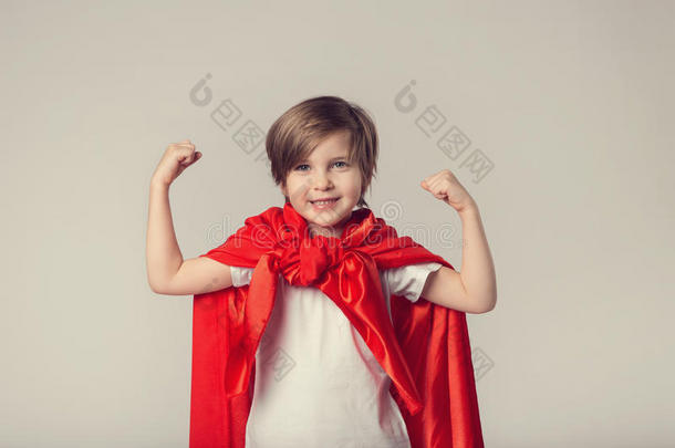 漂亮的女<strong>超人</strong>小孩采用红色的<strong>斗篷</strong>给看她肌肉