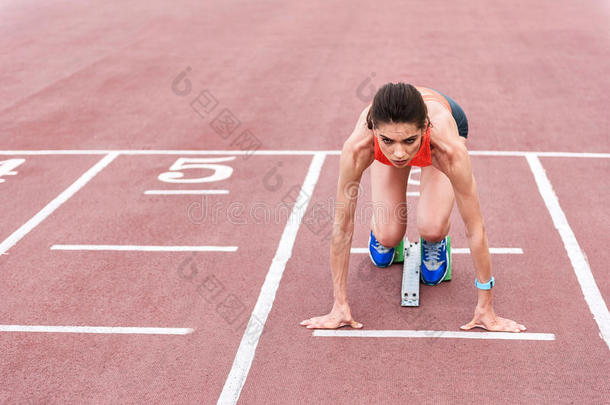 确信的女孩使摆<strong>姿势</strong>采用赛跑者<strong>起跑</strong>时脚底所撑的木块向开始runn采用g